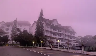 a foggy parking lot in front of a large building at The Antler Silverpark Fraser's Hill in Bukit Fraser