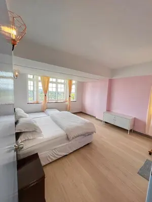 a bedroom with a large bed and pink walls at The Antler Silverpark Fraser's Hill in Bukit Fraser