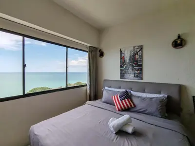 a bedroom with a bed with an american flag pillow at InvincibleSeaview Batu Ferrighi Sri Sayang \u7121\u6575\u6d77\u666f 2-7 in Batu Ferringhi