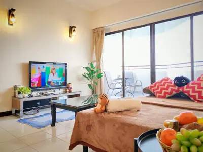 a living room with a television and a table with fruit on it at InvincibleSeaview Batu Ferrighi Sri Sayang \u7121\u6575\u6d77\u666f 2-7 in Batu Ferringhi