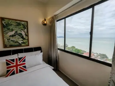 a bedroom with a bed and a large window at InvincibleSeaview Batu Ferrighi Sri Sayang \u7121\u6575\u6d77\u666f 2-7 in Batu Ferringhi