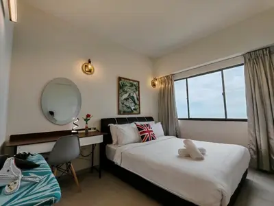 a bedroom with a bed and a desk and a mirror at InvincibleSeaview Batu Ferrighi Sri Sayang \u7121\u6575\u6d77\u666f 2-7 in Batu Ferringhi