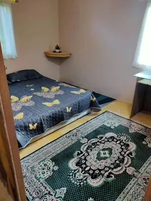 a bedroom with a bed and a rug on the floor at Anjung Afilia 1 in Kuala Kangsar