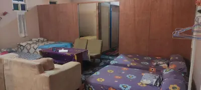 a living room with two beds and a mirror at Afilia 2 in Kuala Kangsar