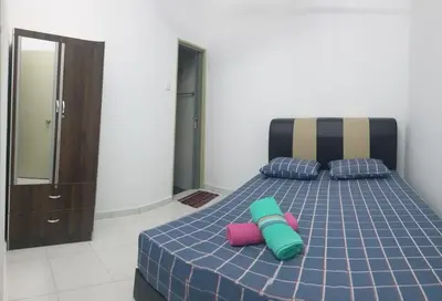 a bedroom with a bed with two pillows on it at HOMESTAY IMPIAN QASEH MANJUNG (MUSLIM) in Seri Manjung
