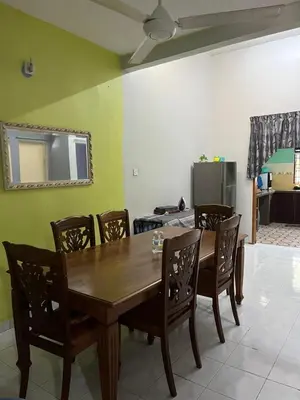a dining room with a wooden table and chairs at RUMAH INAP BANDAR PERDANA in Sungai Petani