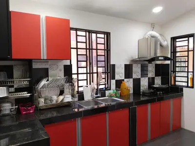 a kitchen with red cabinets and a sink at Homestay YatiMizi (Bungalow Station 18, Ipoh) in Ipoh