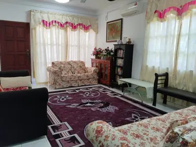 a living room with a couch and a chair and a rug at Homestay YatiMizi (Bungalow Station 18, Ipoh) in Ipoh
