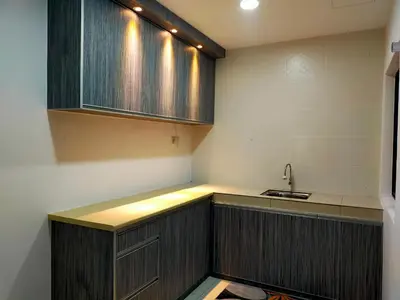 a kitchen with wooden cabinets and a sink at Razads Waterpark Homestay Ipoh in Ipoh