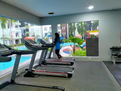 a woman walking on a treadmill in a gym at Razads Waterpark Homestay Ipoh in Ipoh