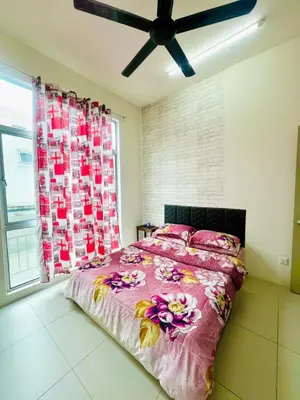 a bedroom with a bed with pink sheets and a ceiling fan at Deq Noor Homestay in Cameron Highlands