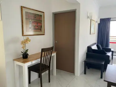 a room with a desk and a chair and a door at Susies Deluxe Seaview Suite Sri Sayang in Batu Ferringhi