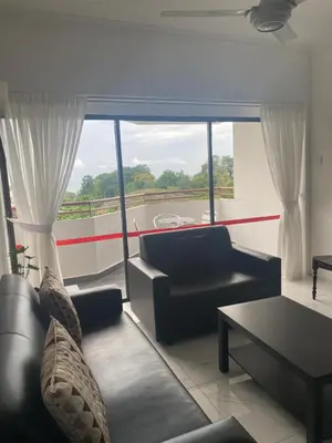 a living room with couches and a large window at Susies Deluxe Seaview Suite Sri Sayang in Batu Ferringhi