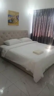 a large white bed in a bedroom with a window at Susies Deluxe Seaview Suite Sri Sayang in Batu Ferringhi