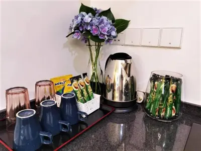 a kitchen counter with a vase of purple flowers at \u5317\u6b27ING\u98ce\u683c\u8c6a\u534e\u65e5\u51fa\u6d77\u666f\u5957\u623f Nordic ING Luxury Seaview Suite in Tanjong Tokong