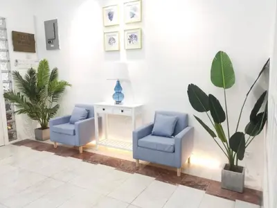 two blue chairs and a table in a room at 527 BeachHouse l 5 bedroom with swimming pool - 3min walk to the beach in Tanjung Bungah