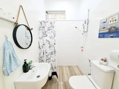 a white bathroom with a sink and a toilet at 527 BeachHouse l 5 bedroom with swimming pool - 3min walk to the beach in Tanjung Bungah