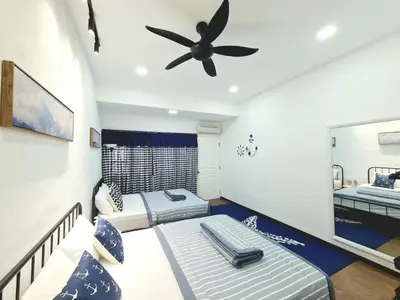 a bedroom with two beds and a ceiling fan at 527 BeachHouse l 5 bedroom with swimming pool - 3min walk to the beach in Tanjung Bungah