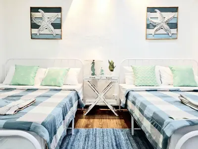 a room with two beds and a table at 527 BeachHouse l 5 bedroom with swimming pool - 3min walk to the beach in Tanjung Bungah