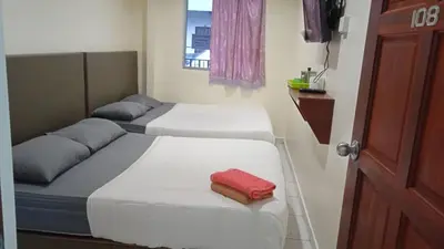 two beds in a small room with a red towel at CH Budget Hotel in Cameron Highlands