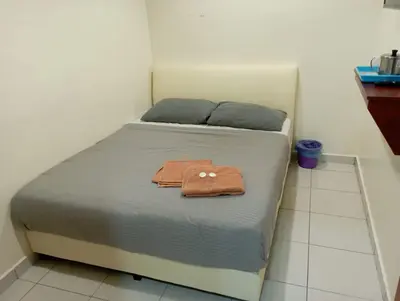 a bed with a brown towel on it in a room at CH Budget Hotel in Cameron Highlands