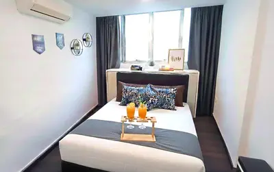 a room with a bed with two drinks on it at SY Staycation - Apartment in Bayan Lepas