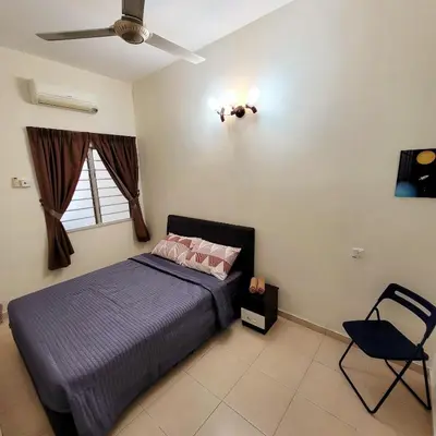 a bedroom with a bed and a chair in it at JackBeansprouts Homestay Botani Ipoh in Ipoh