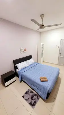 a bedroom with a bed with a blue comforter and a fan at JackBeansprouts Homestay Botani Ipoh in Ipoh
