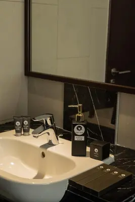 a bathroom sink with a bottle of soap and a mirror at Elegant Seaview Projector Lounge by The Only Bnb in Tanjong Tokong