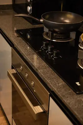 a frying pan on top of a stove in a kitchen at Elegant Seaview Projector Lounge by The Only Bnb in Tanjong Tokong