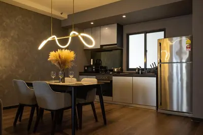 a kitchen with a table and a stainless steel refrigerator at Elegant Seaview Projector Lounge by The Only Bnb in Tanjong Tokong
