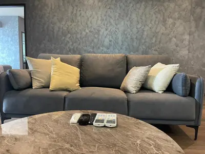 a couch with two remote controls on a table at Elegant Seaview Projector Lounge by The Only Bnb in Tanjong Tokong
