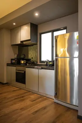 a kitchen with a stainless steel refrigerator and a window at Opulent Seaview Projector Lounge by The Only Bnb in Tanjong Tokong