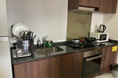 a kitchen with a sink and a microwave at Deluxe Seaview Suite Twin Bed by The Only Bnb in Tanjong Tokong