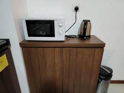 a microwave sitting on top of a wooden cabinet at Deluxe Seaview Suite Twin Bed by The Only Bnb in Tanjong Tokong