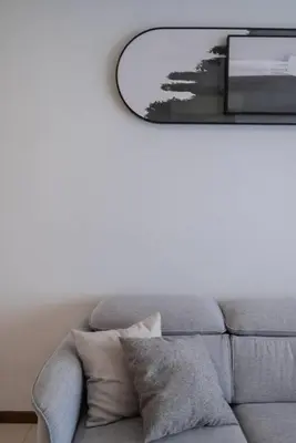 a living room with a gray couch and a mirror at Family Seaview Suite with 3 Rooms by The Only Bnb in Tanjong Tokong