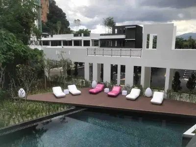 a house with pink and white pillows next to a swimming pool at Ipoh The Cove Elegant Homestay Tambun in Ipoh