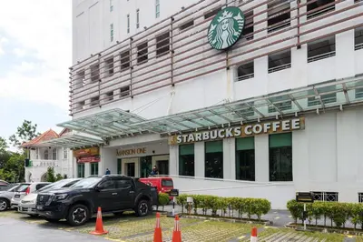 a starbucks coffee building with cars parked in front of it at 2R2B/Cosy House/1~8pax/Gurney/Mansion One in George Town