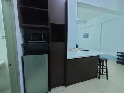 a kitchen with a refrigerator and a counter with a microwave at Golden Hills Pasar Malam 3 Bedroom Apartment J LouvRe in Tanah Rata