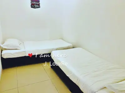 two beds in a room with the words i am never at Golden Hills Pasar Malam 3 Bedroom Apartment J LouvRe in Tanah Rata