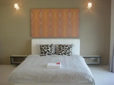 a bedroom with a white bed with two tables at Shamrock Beach Villas Batu Ferringhi Penang in Batu Ferringhi