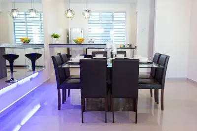 a dining room with a table and black chairs at Shamrock Beach Villas Batu Ferringhi Penang in Batu Ferringhi