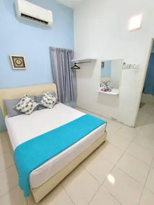 a bedroom with a bed with a blue wall at Santorini 4 Bedrooms Full Air Cond Entire Home by Grab A Stay in Ipoh