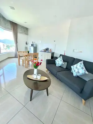 a living room with a blue couch and a table at Octagon Premium Ipoh Town Center 2BR 101 by Grab A Stay in Ipoh