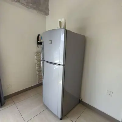 a white refrigerator in a corner of a room at Octagon Premium Ipoh Town Center 2BR 101 by Grab A Stay in Ipoh