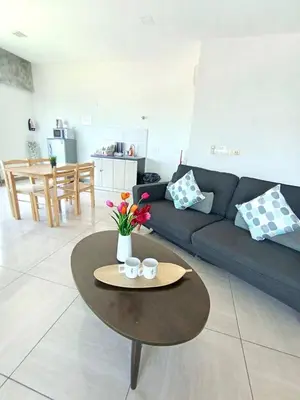 a living room with a couch and a table with flowers at Octagon Premium Ipoh Town Center 2BR 101 by Grab A Stay in Ipoh