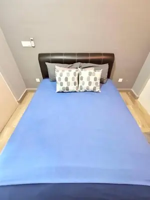 a bed with blue sheets and pillows in a room at Octagon Premium Ipoh Town Center 2BR 121 by Grab A Stay in Ipoh