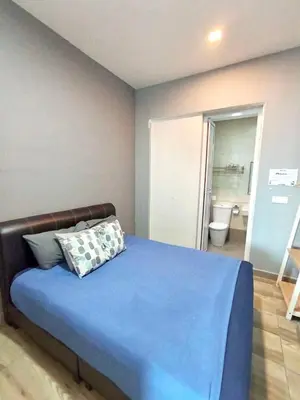 a bedroom with a blue bed and a bathroom at Octagon Premium Ipoh Town Center 2BR 121 by Grab A Stay in Ipoh