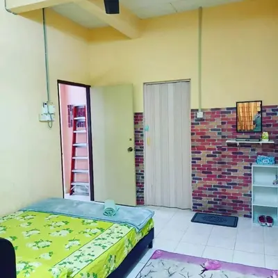 a room with a bed and a door with a ladder at Homestay Musafir 3.0 in Seri Iskandar