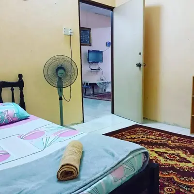a bedroom with a bed with a fan and a mirror at Homestay Musafir 3.0 in Seri Iskandar
